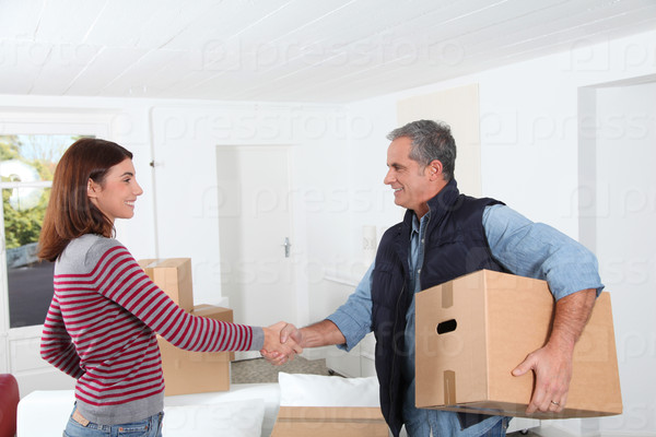 Young woman with removal man holding boxes, stock photo