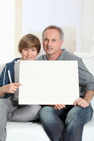 Man and young boy holding white message board