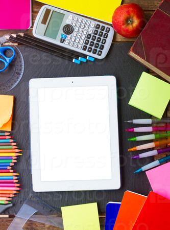 Back to school supplies as a frame of tablet on blackboard, top view