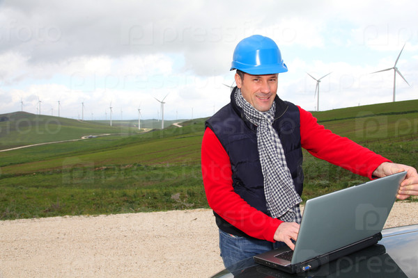 Engineer working on laptop computer in wind turbines field