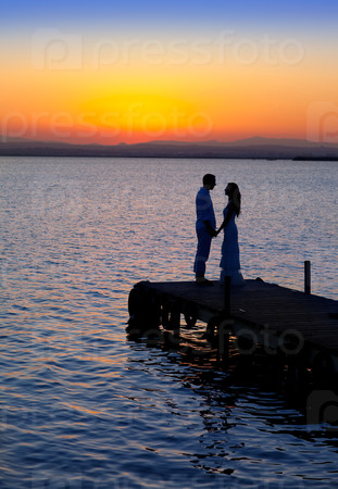 Couple in love back light silhouette at lake
