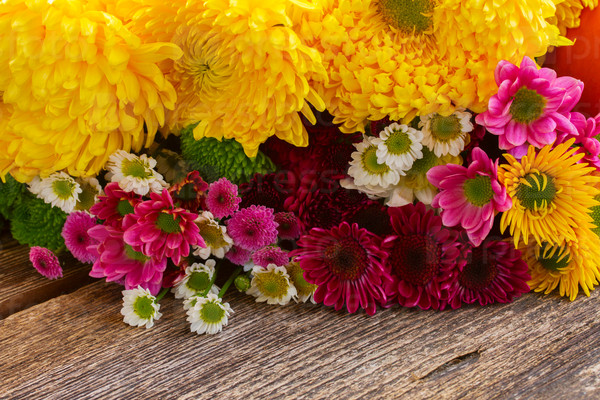 Bunch of chrysanthemum flowers on wooden table, stock photo