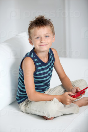 Little boy playing video games on sofa
