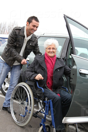 Молодой человек, помощь старший женщина в инвалидной коляске