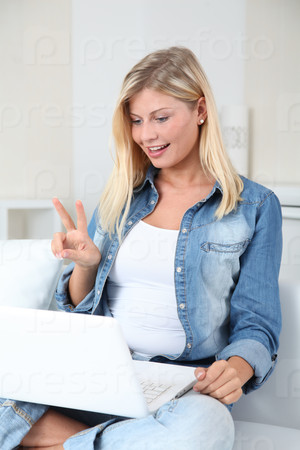 Beautiful blond woman chatting on internet with web camera