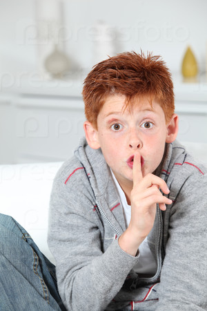 Young boy with finger on his mouth