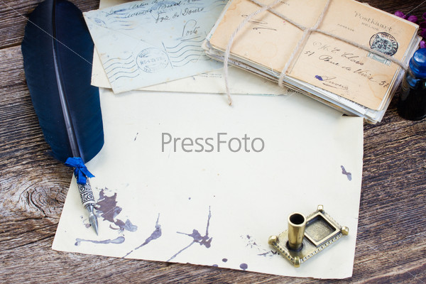 pile of  antique letters with ink stains  and blue  feather pen