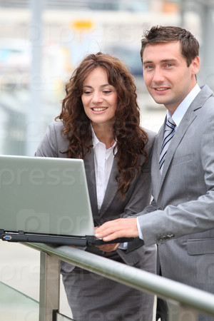 Business people working on laptop computer outside