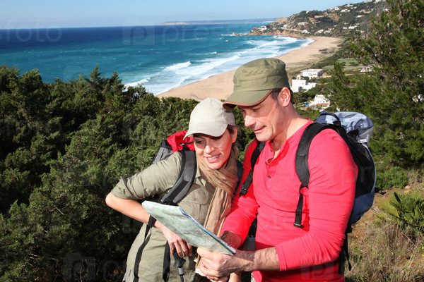 Couple looking at map on a hiking day, stock photo
