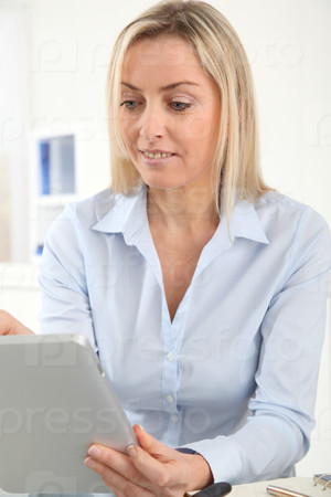 Portrait of office worker using electronic tablet in office