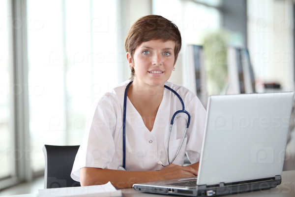 Closeup of beautiful nurse in front of laptop computer
