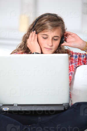 Teenager with headphones and laptop computer