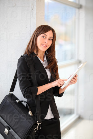 Businesswoman standing in hall with electronic pad
