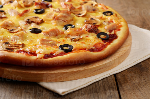 Mushroom and chicken pizza on the wooden board closeup