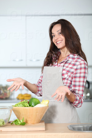 Beautiful woman standing in kitchen with apron