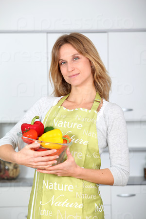 Woman in kitchen ready to prepare meal with vegetables