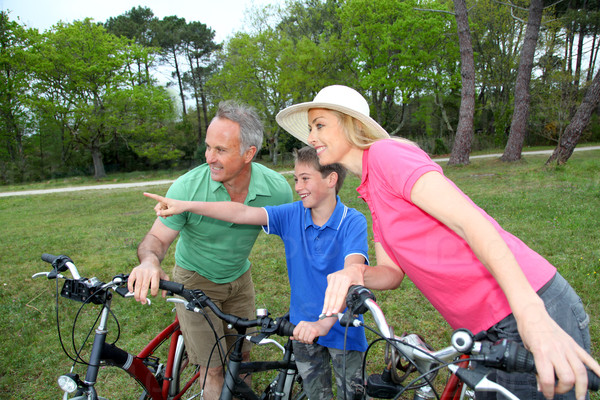 Family on a bike ride standing by a lake
