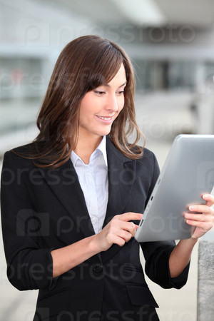 Businesswoman standing outside with electronic tab