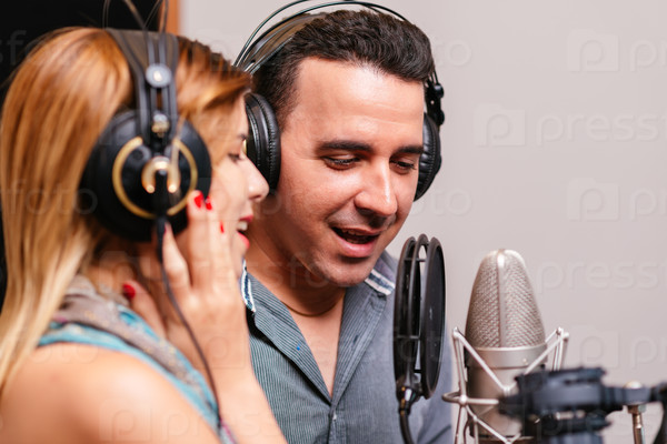 Hispanic music band of two recording a song in the studio