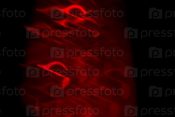 Red bokeh in a shape of a music note on dark background.