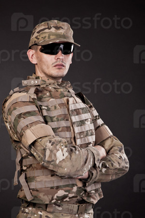 Half length photogaph portrait of adult man in his  Army uniform; copy space on black background