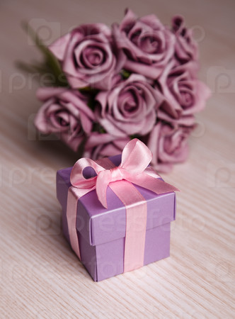 violet flowers and gift box with pink ribbon