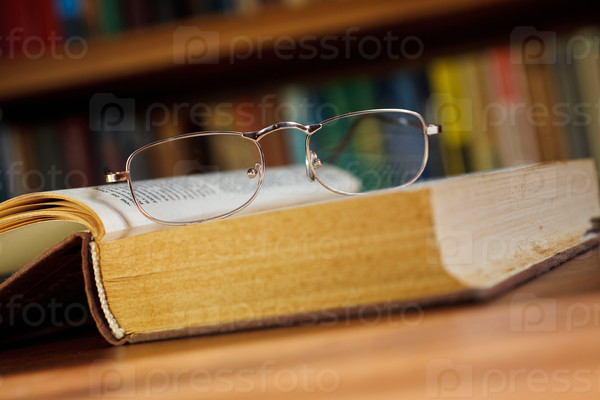 glasses and book on background bookcase