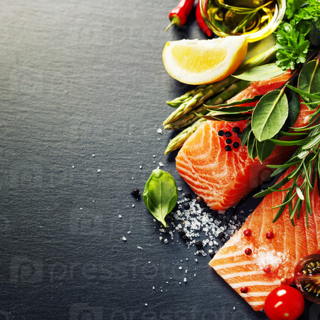 Delicious  portion of fresh salmon fillet  with aromatic herbs, spices and vegetables - healthy food, diet or cooking concept