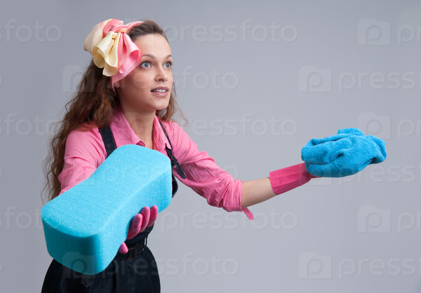 young housewife with cleaning sponge. Isolated over gray