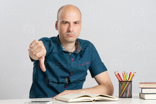 bald man with thumbs down at the desk