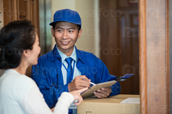 Smiling delivery man using small credit card reader to accept payment