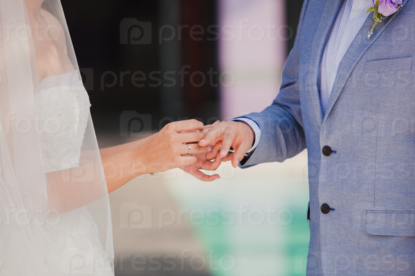 Groom wearing the Diamond ring to bride hand in wedding ceremony.