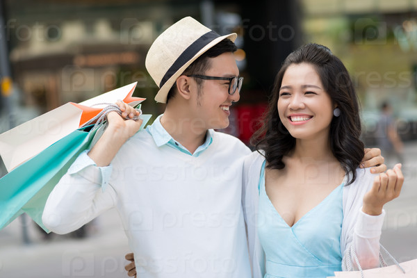 Portrait of laughing young couple with paper bags