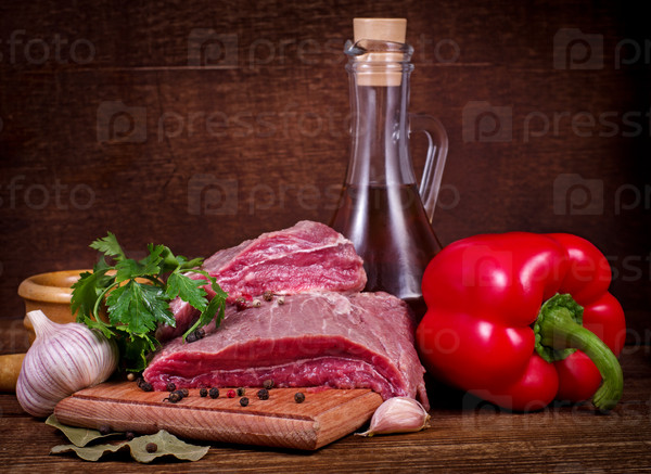Crude meat and spice on wooden background