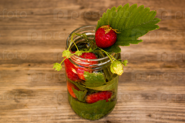 retro glass jars of lemonade with strawberries and mint on wooden table