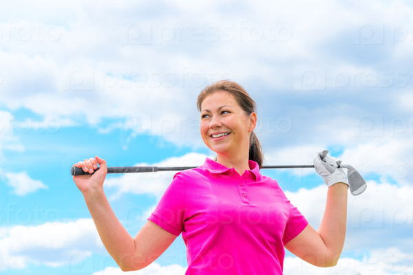 Happy portrait of a woman golfer with golf club against the sky, stock photo