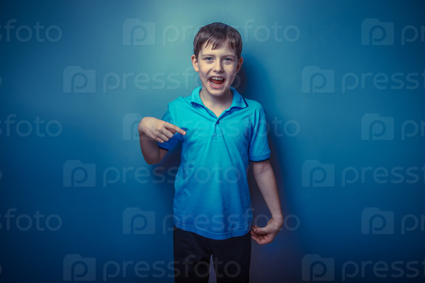 Boy teenager European appearance decade fingers pointing down on a gray  background retro photo effect