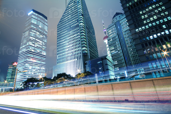 The urban background of modern office buildings car night light trails in Shanghai