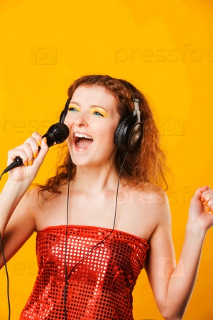 Young red-haired woman with microphone. Singer. Karaoke