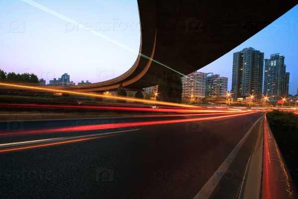 Large urban ring highway viaduct long exposure photo light trails night scene