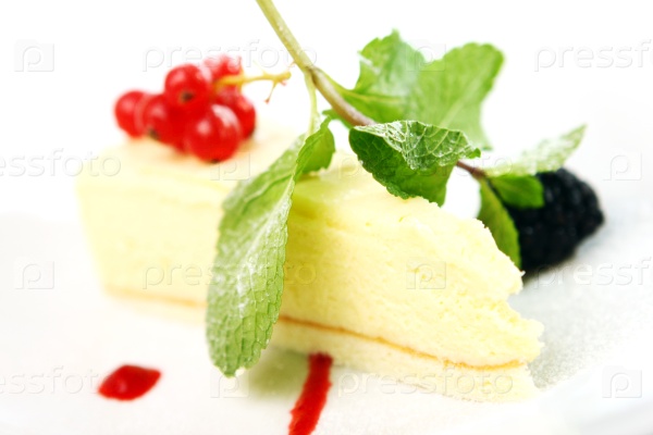 Fresh cheesecake dessert with mint and berries on a white plate, stock photo