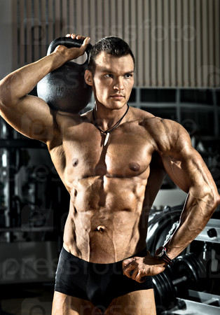 portrait very brawny athletic guy - bodybuilder,   with  weight, in gym