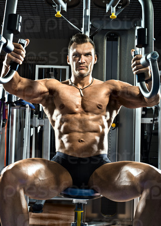 very brawny guy bodybuilder ,  execute exercise  on gym apparatus Butterfly Machine, in gym
