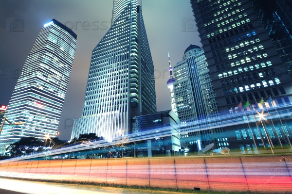 The City background of modern office buildings car night light trails in Shanghai