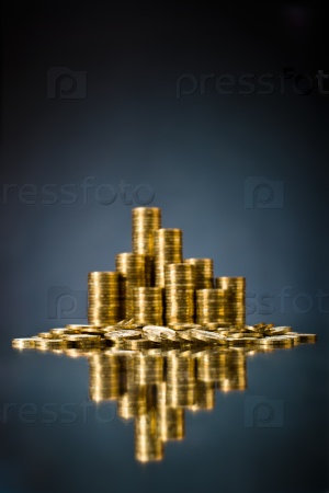 still life of very many rouleau gold  monetary or change coin, on dark blue  background