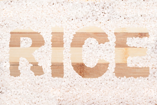 Rice grain. Word rice written on wooden cutting board. For background