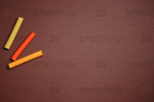 Empty brown cardboard background and multicolored pastel - art utensil