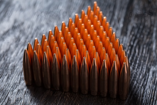 Macro shot of copper bullets that are in many rows to form a tri