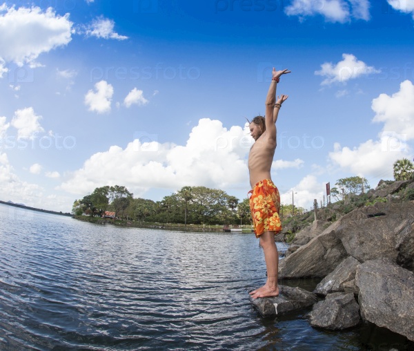 Teenage boy jumping in the river