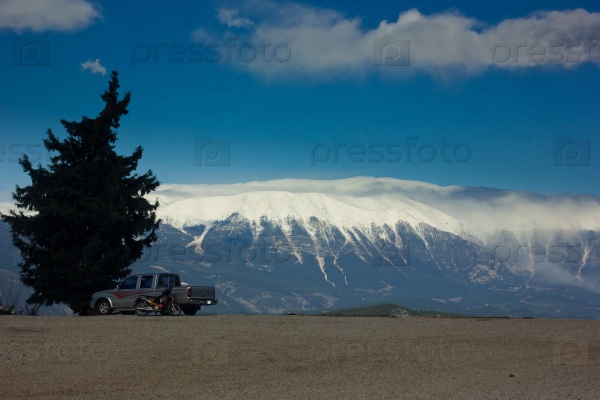 car and bike on the road with tree, mountains background